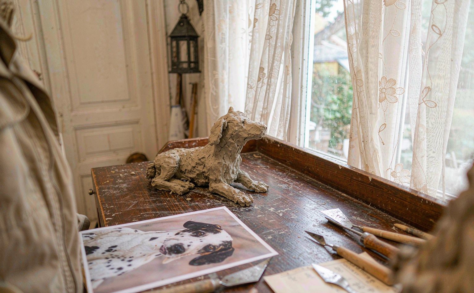 Artist's studio desk with a custom pet portrait keepsake being crafted from a reference photo